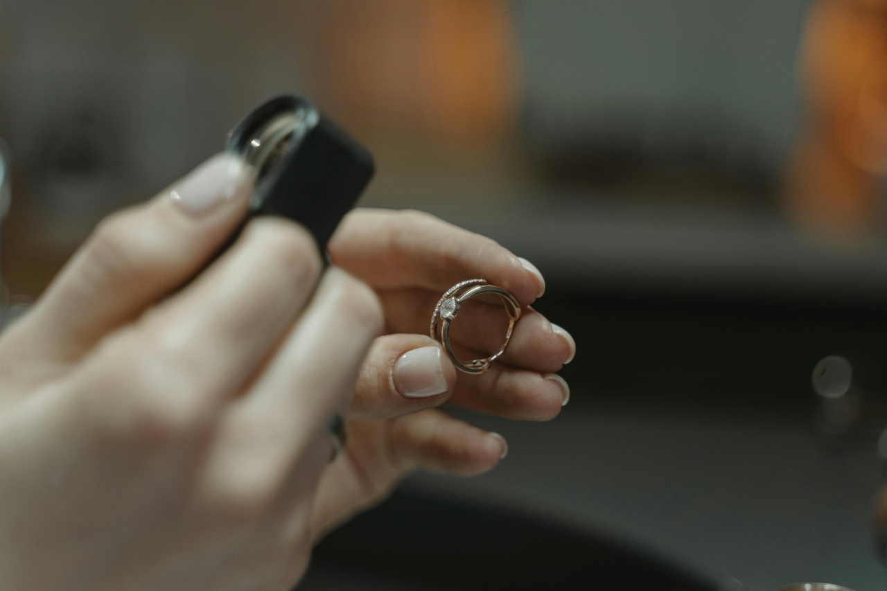 A jeweler examines a diamond ring with a magnifying glass