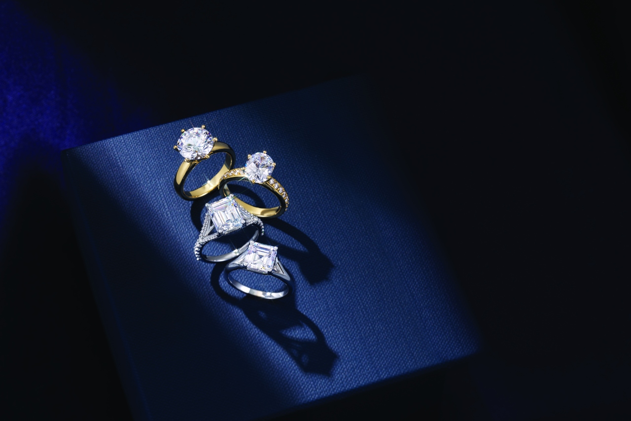 A selection of yellow gold and white gold diamond engagement rings on a dark blue background