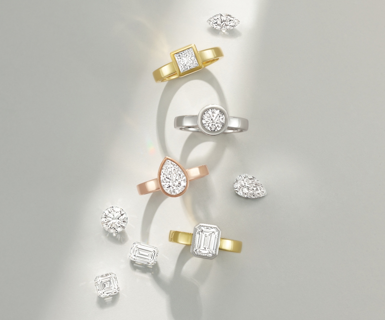Four bezel set solitaire engagement rings with thicker bads and a few loose diamonds