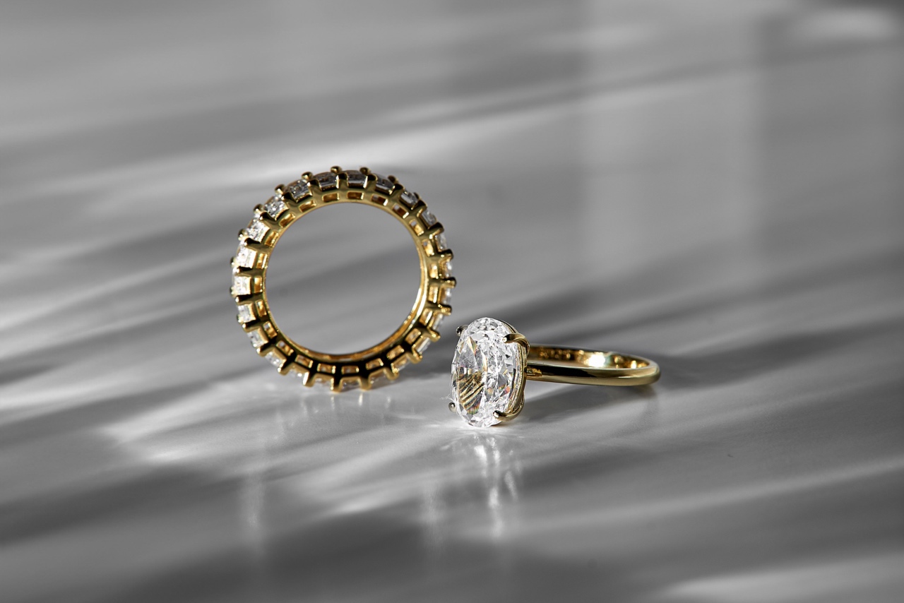 A yellow gold wedding set featuring eternity diamond wedding bands and solitaire oval cut diamond engagement ring.