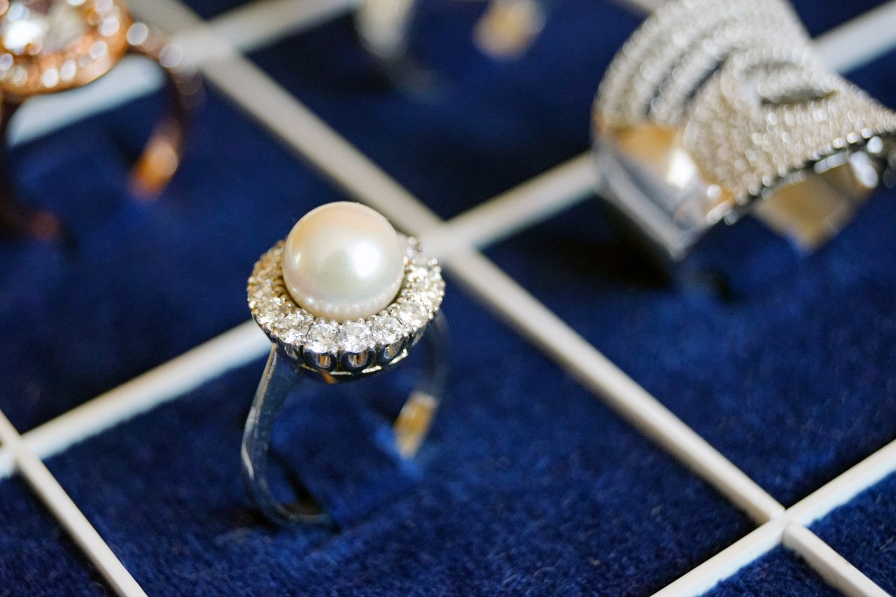 A blue velvet ring display with various rings in each square.