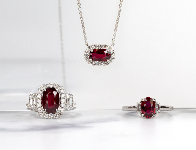A photo showing ruby and diamond jewelry. Featuring a necklace and two rings.