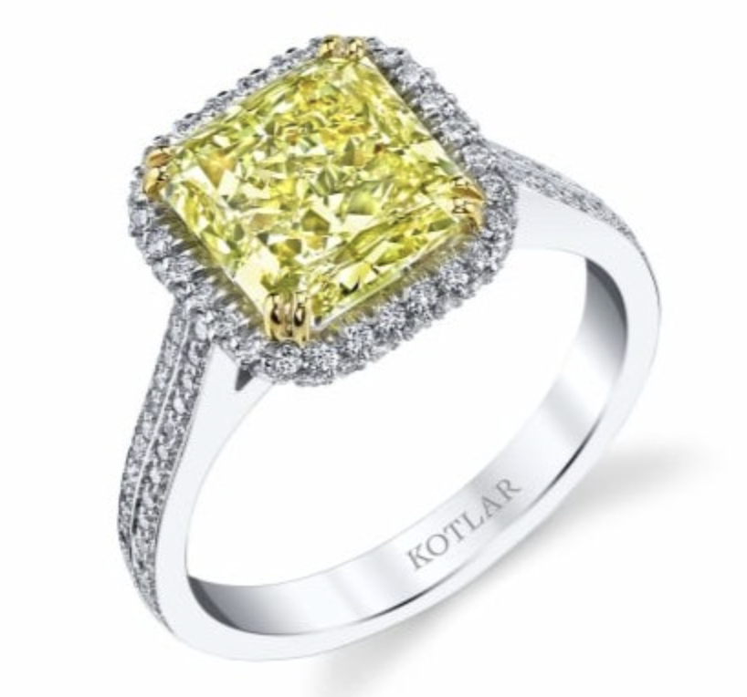 A platinum halo engagement ring with yellow diamond center stone