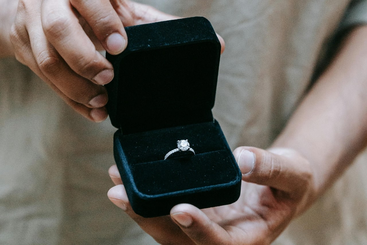 A white gold side stone engagement ring inside the turquoise jewelry box