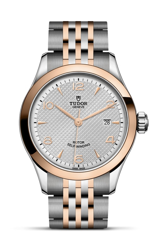 A rose gold and stainless steel watch with rose gold hands and arab numerals, as well as data complication.
