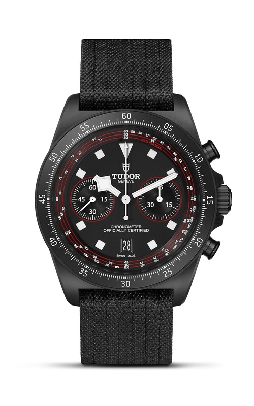 A TUDOR watch with a black dial and fabric strap.