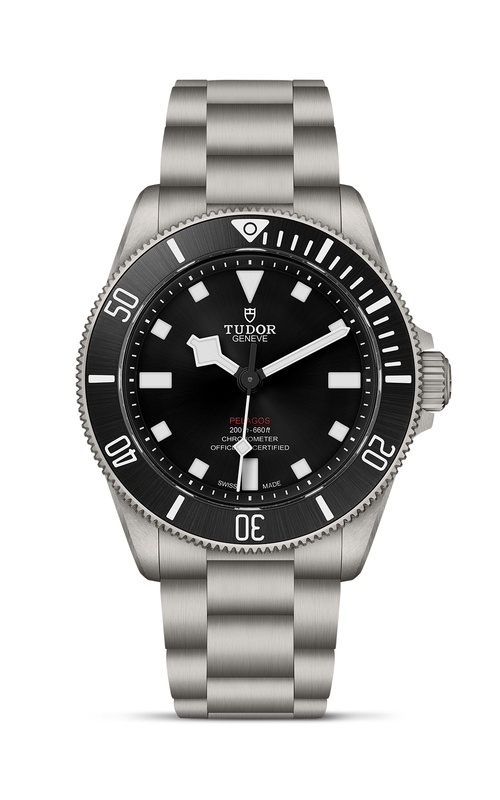 A TUDOR watch with a black dial and stainless steel bracelet.