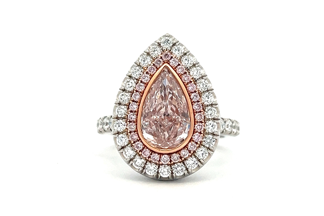 A double halo engagement ring with a pear shape center stone and milgrain detailing.