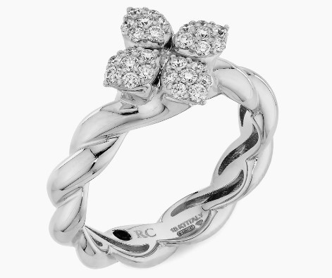 A white gold twisted ring with diamond encrusted flowers on a white background