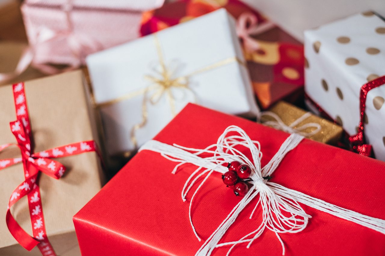 A collection of festive, colorful gift boxes with various wrapping styles and bows.