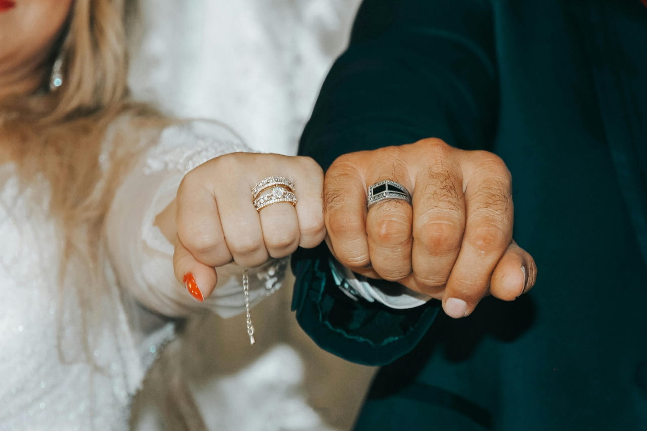 A husband and wife showing off their anniversary bands