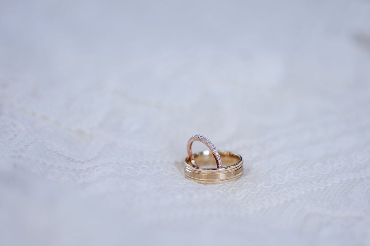 Two gold wedding bands resting on pristine white lace. Two gold wedding bands resting on pristine white lace.
