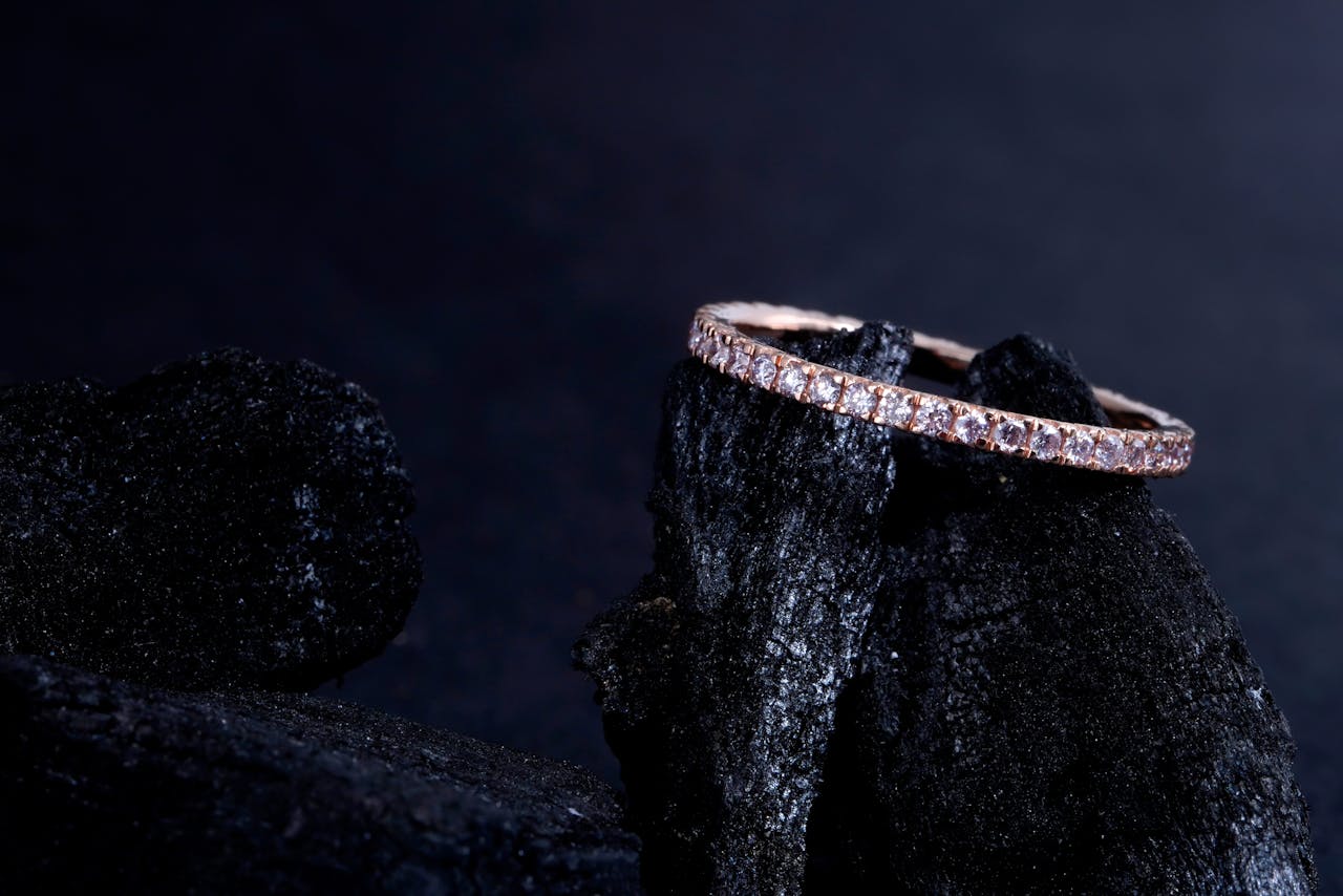 A close-up of an emerald-cut diamond carefully held by jeweler’s tweezers.